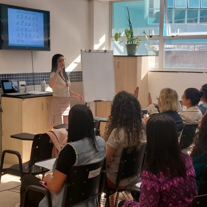 Profissionais da saúde de Barueri em aula prática de Libras no auditório do Centro de Especialidades