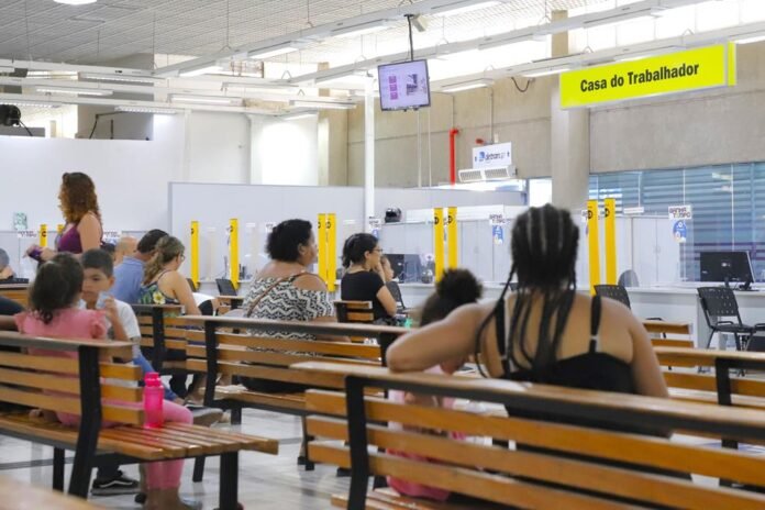 Painel de vagas de emprego em Barueri com profissionais buscando atendimento no Ganha Tempo