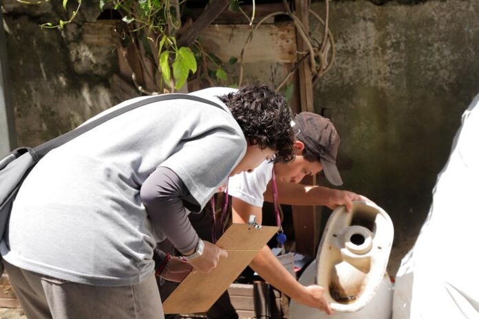 Agente de saúde de Barueri inspecionando quintal durante mutirão de combate à dengue