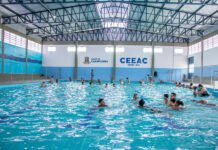 Conheça os CEEACs de Carapicuíba: educação e lazer para a comunidade Fachada do CEEAC Tancredão em Carapicuíba com letreiro da prefeitura e área esportiva ao fundo.