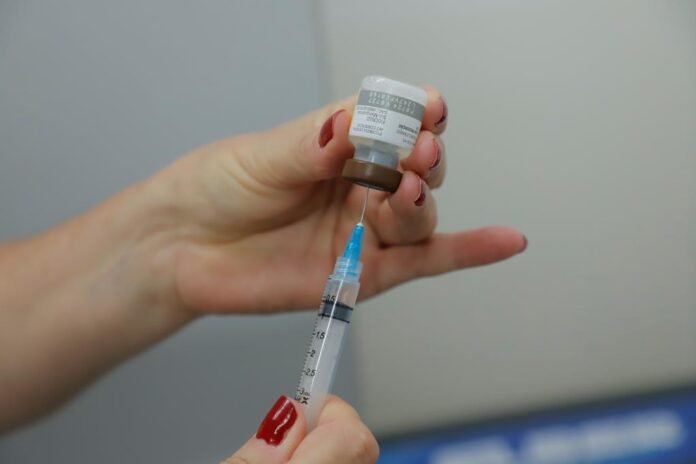 Profissional de saúde realizando vacinação em Barueri durante a Semana Municipal de Imunização