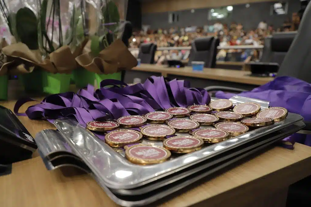 Mulher recebendo troféu em evento oficial da prefeitura de Barueri, representando o prêmio mulher destaque