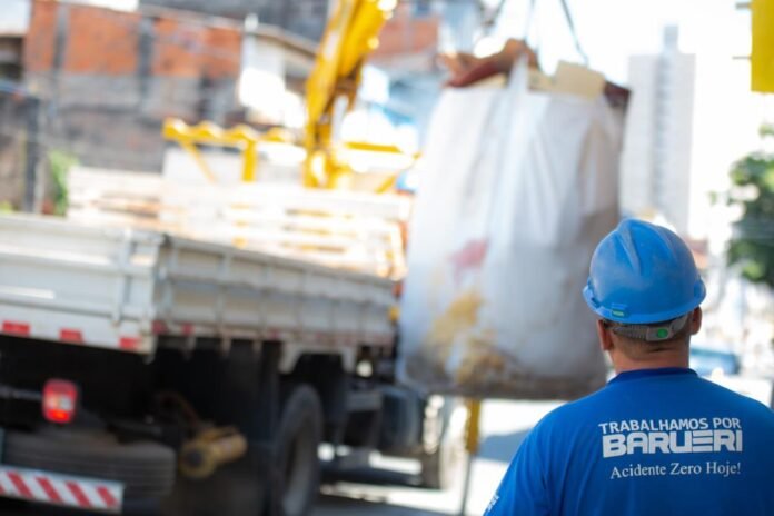 Caminhão da Prefeitura de Barueri realizando a coleta de big bag do serviço Papa-Entulho em via pública